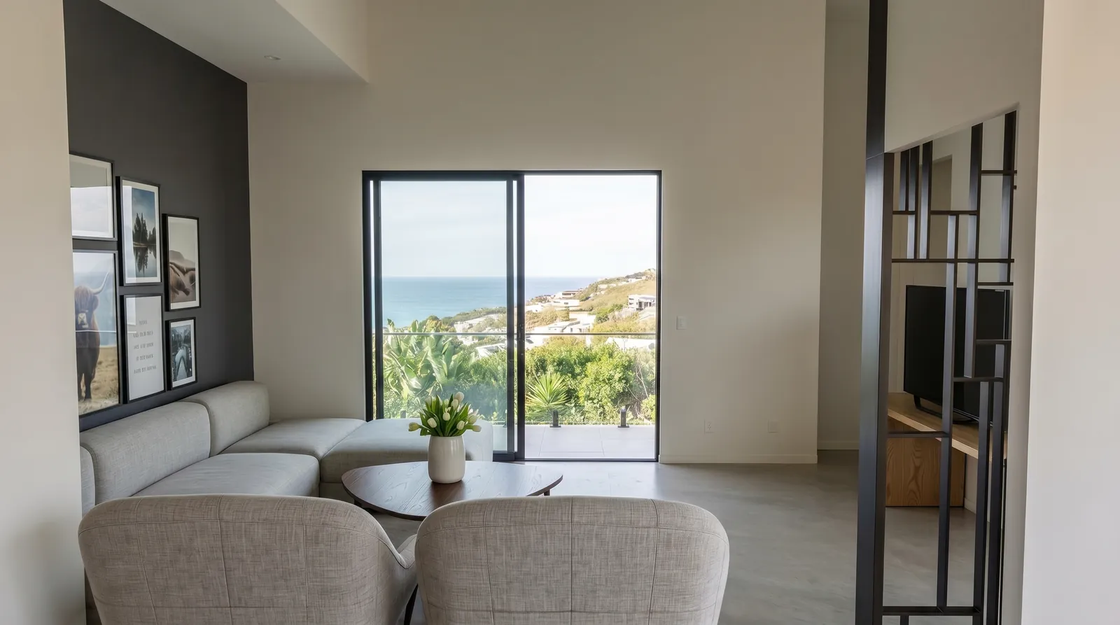 Living corner with framed photography opening onto the sea terrace.
